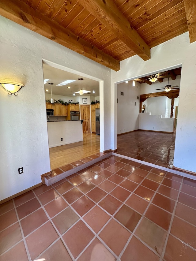 2638 Aloysia Ln NW, Albuquerque, NM 87104 - unfurnished living room with tile patterned flooring, baseboards, ceiling fan, beam ceiling, and wooden ceiling