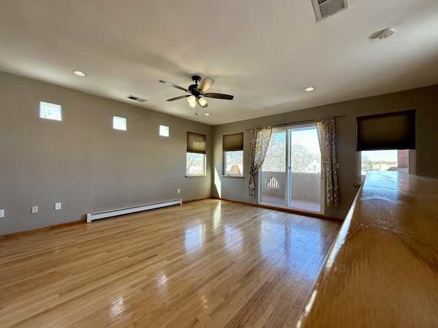 2638 Aloysia Ln NW, Albuquerque, NM 87104 - unfurnished room with wood finished floors, a ceiling fan, visible vents, and a baseboard radiator