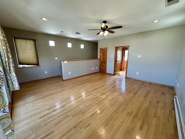 2638 Aloysia Ln NW, Albuquerque, NM 87104 - empty room with light wood finished floors, visible vents, baseboard heating, and ceiling fan