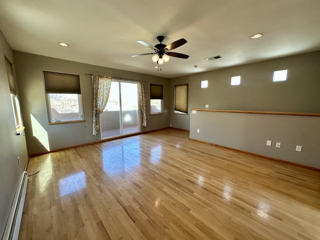 2638 Aloysia Ln NW, Albuquerque, NM 87104 - spare room with light wood finished floors, visible vents, a baseboard heating unit, baseboards, and ceiling fan