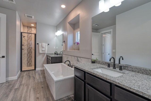 7754 Majesty Ct NW, Albuquerque, NM 87107 - full bathroom with a shower stall, a freestanding bath, wood finished floors, two vanities, and recessed lighting