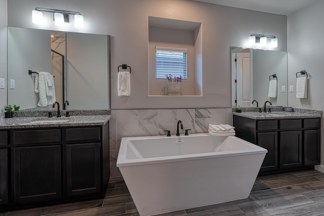 7754 Majesty Ct NW, Albuquerque, NM 87107 - bathroom featuring wood tiled floors, a freestanding bath, and two vanities