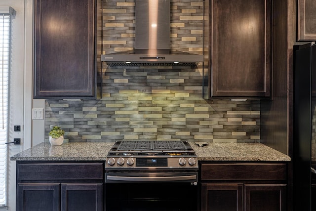 7754 Majesty Ct NW, Albuquerque, NM 87107 - kitchen featuring stainless steel gas range oven, wall chimney range hood, dark brown cabinetry, decorative backsplash, and light stone countertops