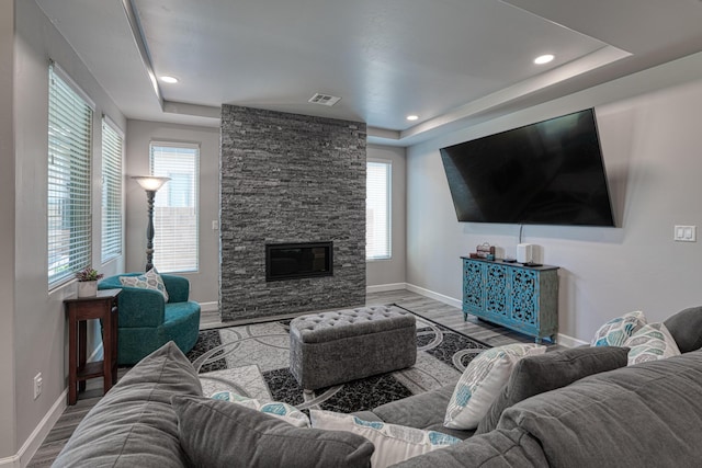 7754 Majesty Ct NW, Albuquerque, NM 87107 - living area featuring a tray ceiling, baseboards, wood finished floors, a stone fireplace, and recessed lighting