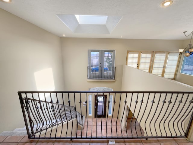 stairs featuring recessed lighting, an inviting chandelier, a skylight, and tile patterned flooring