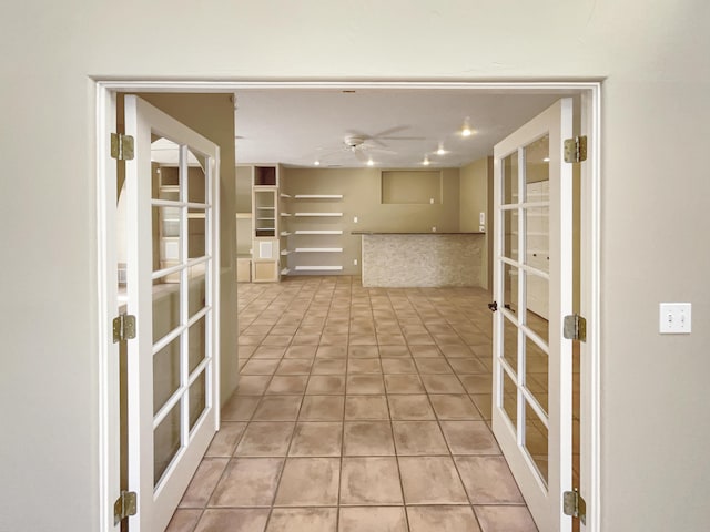 hallway featuring light tile patterned floors and french doors