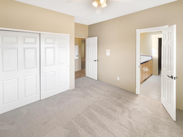 unfurnished bedroom with a ceiling fan, light tile patterned floors, light colored carpet, and a closet