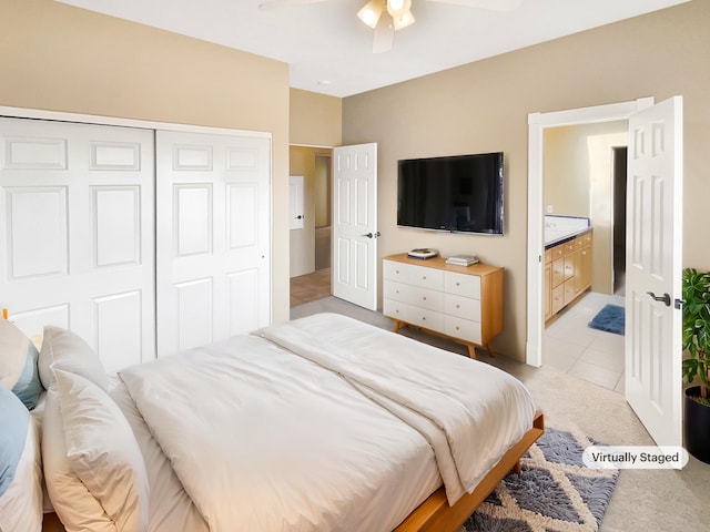 bedroom with light tile patterned floors, a closet, connected bathroom, and ceiling fan