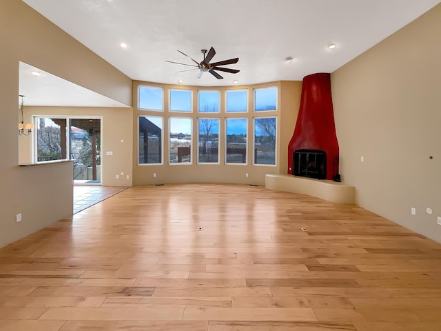 unfurnished living room featuring light wood finished floors, recessed lighting, a wood stove, and a ceiling fan
