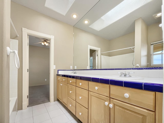 bathroom with tile patterned flooring, ceiling fan, double vanity, recessed lighting, and a sink