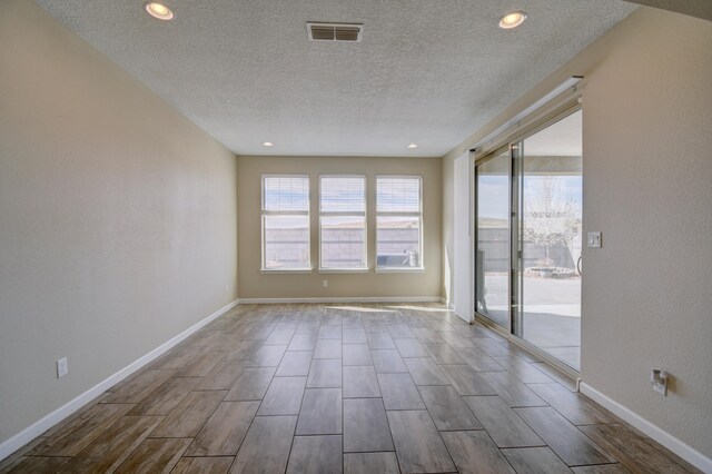 12136 Bear Valley Ln NW, Albuquerque, NM 87120 - spare room with a textured ceiling, healthy amount of natural light, wood tiled floors, baseboards, and recessed lighting