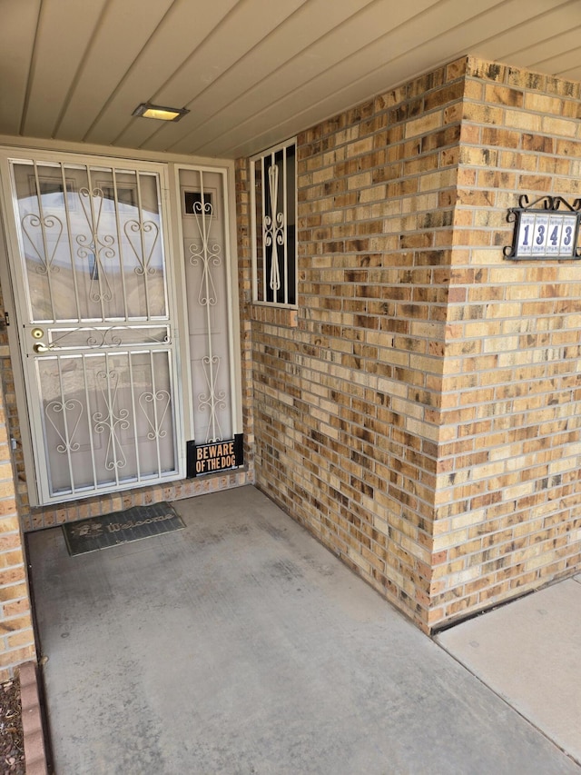 property entrance featuring brick siding