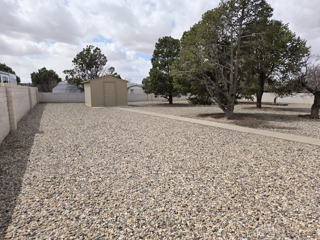 view of yard featuring an outbuilding, a shed, and a fenced backyard