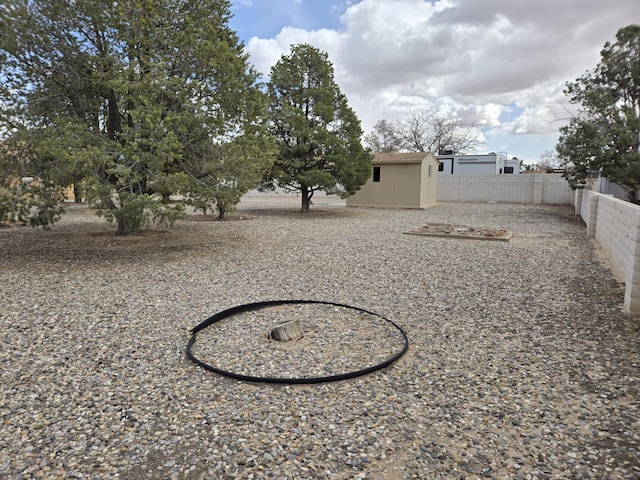 view of yard featuring a storage unit, a fenced backyard, and an outdoor structure
