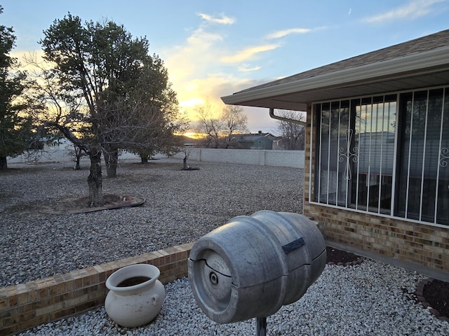 yard at dusk featuring fence