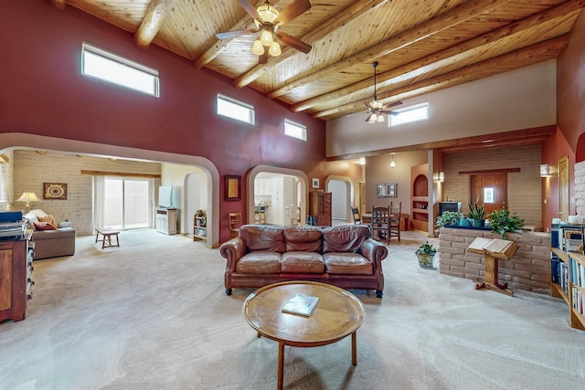 712 Navarra Way SE, Albuquerque, NM 87123 - living room featuring ceiling fan, arched walkways, wooden ceiling with exposed beams, a towering ceiling, and carpet flooring