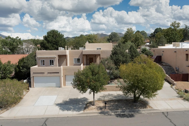 712 Navarra Way SE, Albuquerque, NM 87123 - pueblo-style house with stucco siding, an attached garage, and concrete driveway