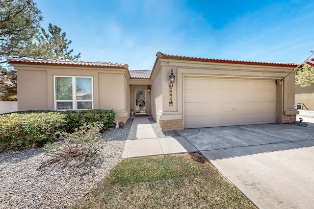 mediterranean / spanish home featuring a garage, stucco siding, driveway, and a tile roof