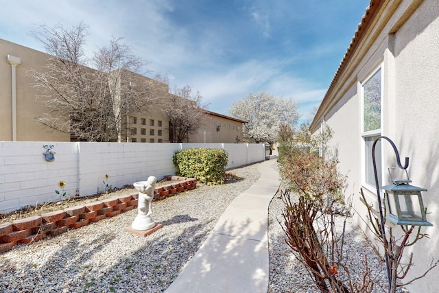 view of yard featuring a garage and a fenced backyard