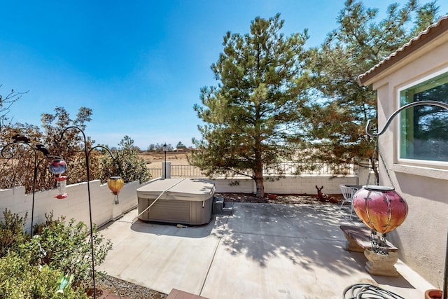 view of patio / terrace featuring a fenced backyard and a hot tub