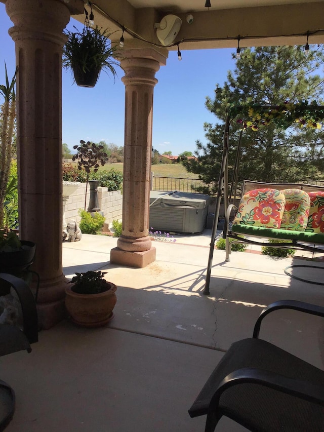 view of patio featuring a hot tub and fence