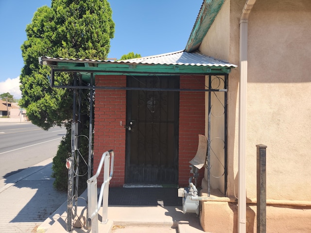 912 Camino Del Pueblo, Bernalillo, NM 87004 - entrance to property featuring metal roof, brick siding, and stucco siding