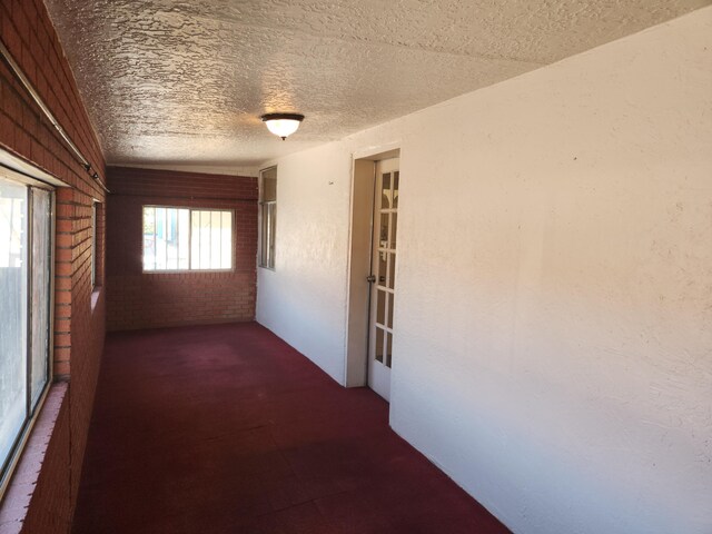 912 Camino Del Pueblo, Bernalillo, NM 87004 - corridor with brick wall and a textured ceiling