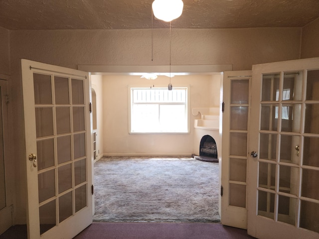 912 Camino Del Pueblo, Bernalillo, NM 87004 - interior space featuring carpet, arched walkways, french doors, and a fireplace with raised hearth