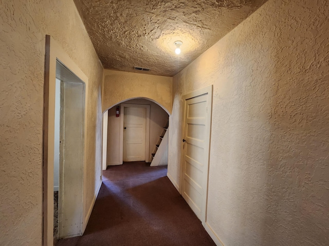 912 Camino Del Pueblo, Bernalillo, NM 87004 - hallway featuring visible vents, stairway, arched walkways, dark colored carpet, and a textured wall