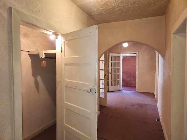 912 Camino Del Pueblo, Bernalillo, NM 87004 - corridor featuring arched walkways, baseboards, carpet, and a textured wall