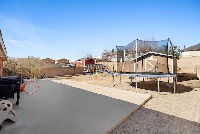 9405 Vervain Dr NW, Albuquerque, NM 87114 - view of patio / terrace featuring a trampoline, a fenced backyard, playground community, and an outdoor structure
