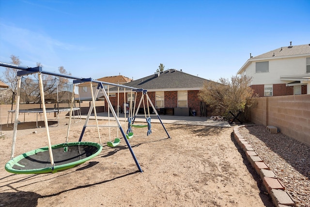 9405 Vervain Dr NW, Albuquerque, NM 87114 - rear view of house featuring a trampoline, a fenced backyard, playground community, and brick siding
