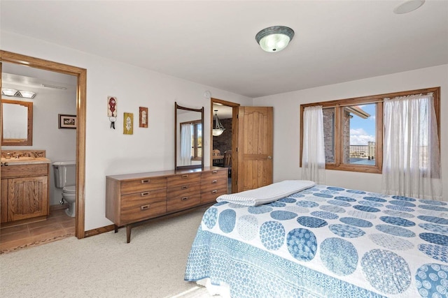 bedroom featuring light carpet and ensuite bathroom
