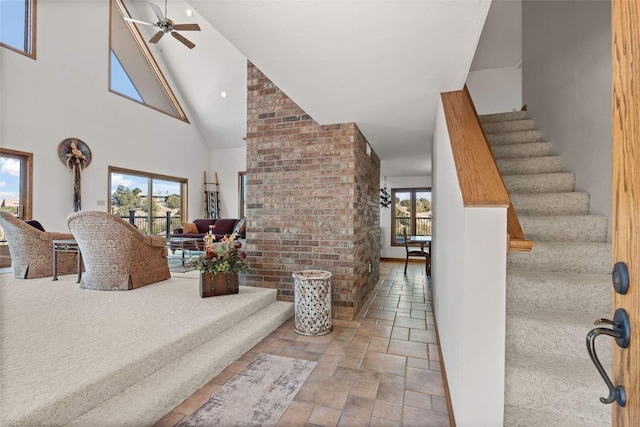 interior space with stone tile flooring, ceiling fan, and a high ceiling