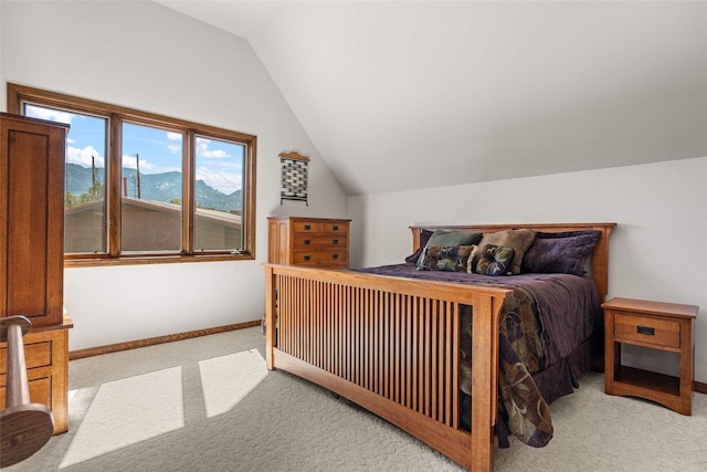carpeted bedroom with baseboards and lofted ceiling