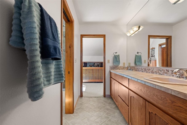 full bath featuring double vanity, baseboards, and a sink