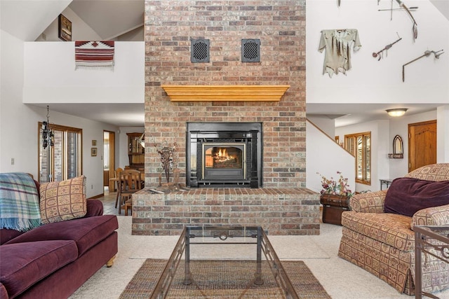 living room featuring a towering ceiling, a brick fireplace, and carpet floors