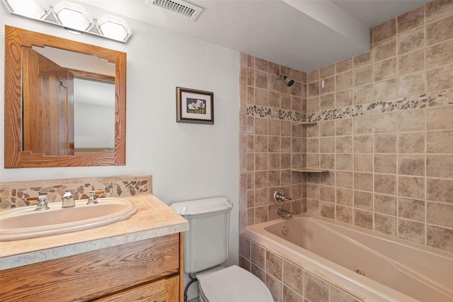 full bathroom with toilet, vanity, tiled shower / bath combo, and visible vents