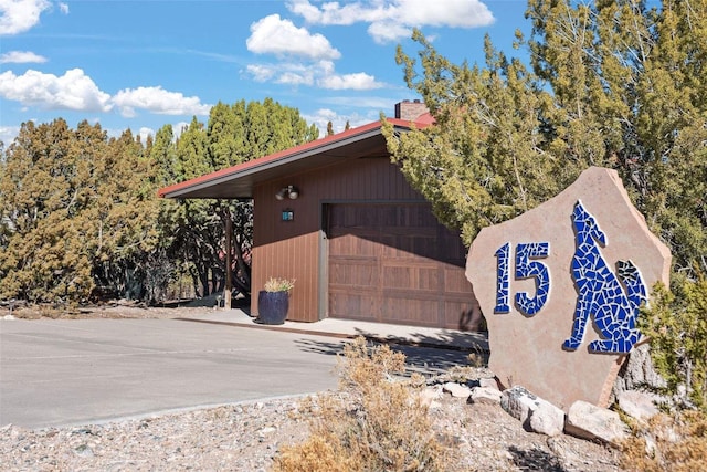 view of side of home with a garage and concrete driveway