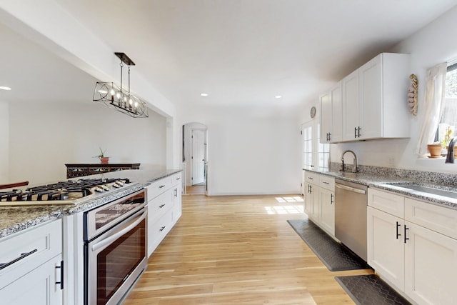 kitchen with light wood-type flooring, a sink, a wealth of natural light, and stainless steel appliances