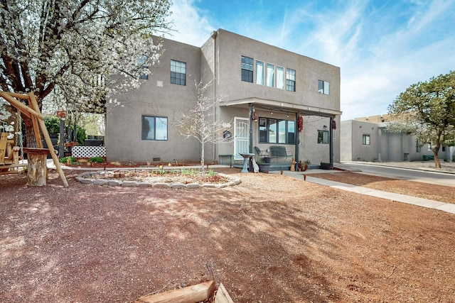 rear view of house featuring stucco siding