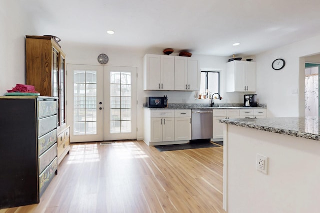kitchen featuring black microwave, french doors, white cabinetry, stainless steel dishwasher, and light wood finished floors