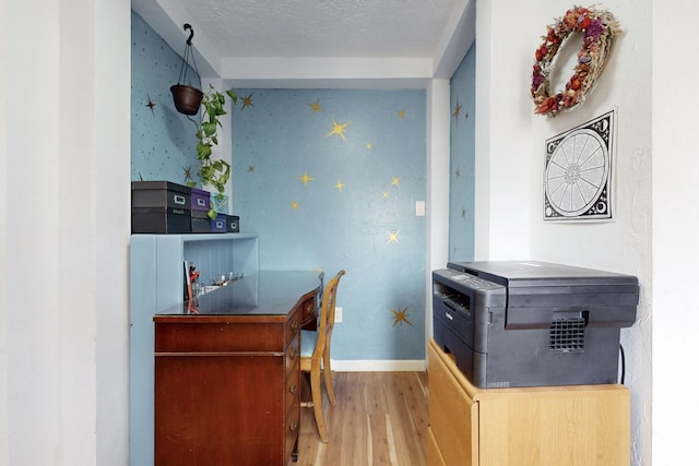 kitchen featuring a textured ceiling, wood finished floors, and baseboards