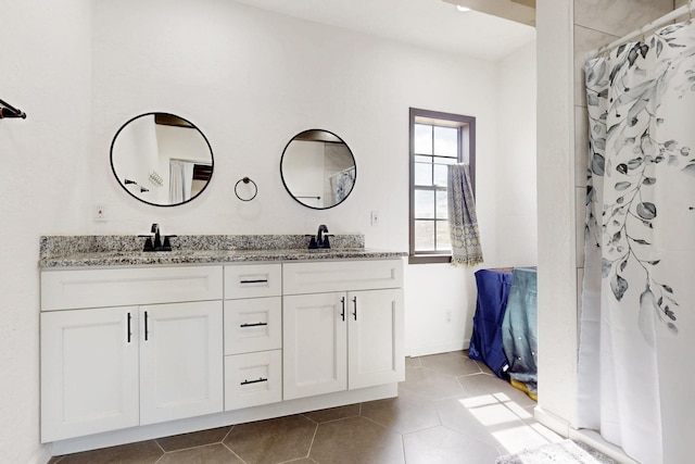 full bathroom featuring double vanity, a sink, and tile patterned flooring