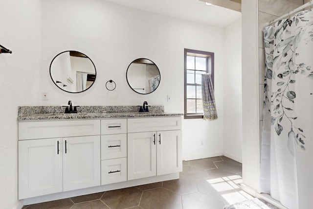 full bathroom with tile patterned flooring, double vanity, and a sink