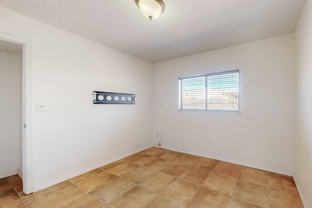 6817 Armand Rd NW, Albuquerque, NM 87120 - spare room with light tile patterned floors, baseboards, and a textured ceiling