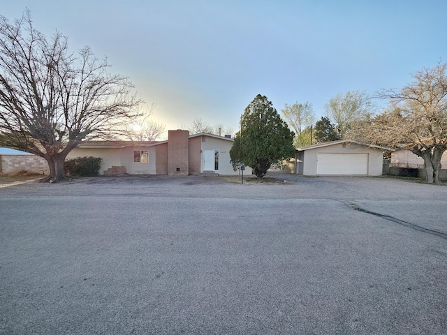view of front of property featuring a detached garage, an outdoor structure, and stucco siding