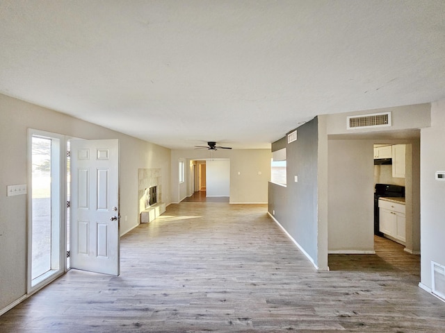 hallway featuring plenty of natural light, visible vents, and wood finished floors