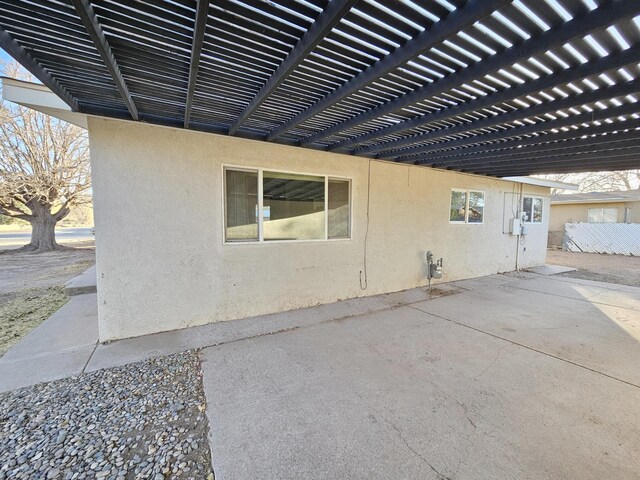 exterior space with a pergola, a patio area, and stucco siding