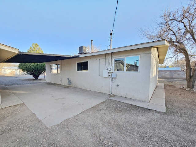 back of property with cooling unit and stucco siding
